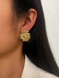 Close-up of a model wearing a 18K gold sunflower earring with intricate petal textures