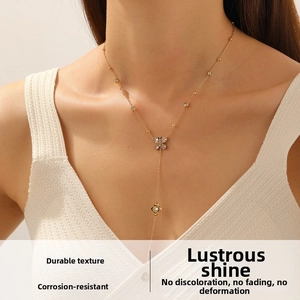 Detailed view of a gold-plated Y-shaped necklace with butterfly and flower charms