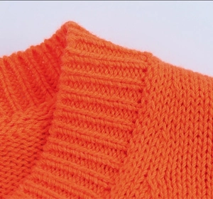 Gros plan détaillé sur la maille orange vif montrant la texture fine du tricotage