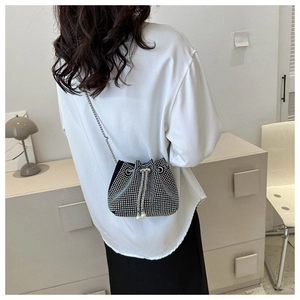 Detail of rhinestone bucket bag with pearl tassels and silver metal chain strap