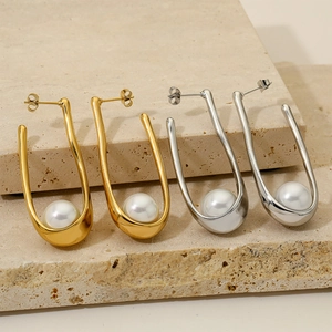 Minimalist U-shaped earrings with pearls in gold and silver finish on a stone base