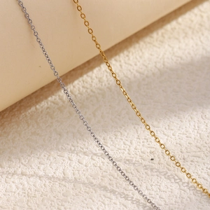 Macro shot of 1.4mm gold and silver stainless steel cross chains with polished link detail