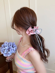 Detail of pink plaid scrunchie with silver bow on ponytail for sweet aesthetic style