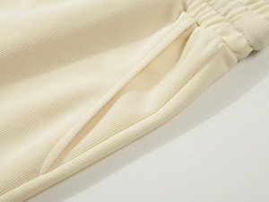 Detail of elastic waistband and side pockets on heavy cotton knit cream athletic shorts