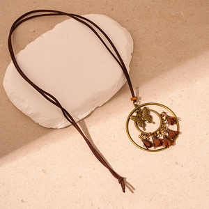 Detail view of bohemian butterfly pendant with bronze metal and brown fabric tassels