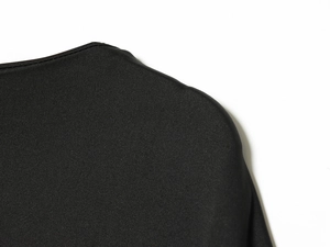 Detailed close-up of shoulder seam and knit fabric texture of a black midi dress
