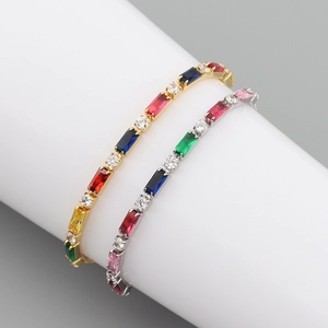 Detail of colorful zircon tennis bracelets in gold and silver settings on white display