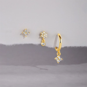 Detail of gold flower earrings set featuring zircon inlays and delicate floral charms