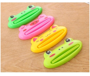 Macro view of four cute cartoon animal plastic toothpaste squeezers on a wooden surface