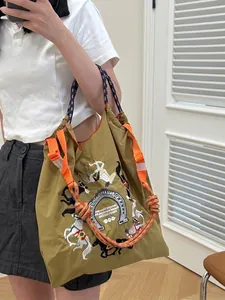 Mustard yellow nylon tote bag with equestrian embroidery and colorful braided handles