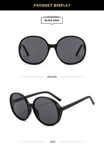 Detailed front and side view of large round black frame sunglasses with grey lenses