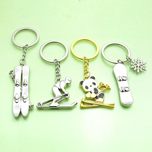 Custom metal keychain featuring downhill skier and panda motifs in silver and gold finish