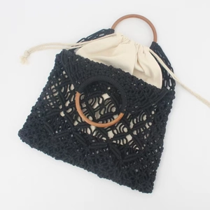 Handmade black macrame cotton rope beach bag with round wooden handles and drawstring pouch