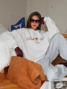 Λεπτομέρεια γκρι oversized φούτερ με κέντημα rich girl και λογότυπο με στέμμα