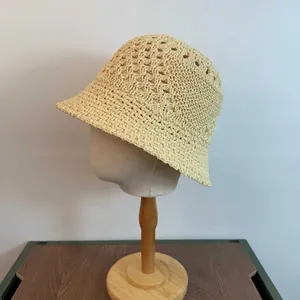 Detail view of the intricate hollow knit pattern on a cream crochet bucket sun hat