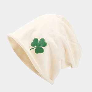 Dettaglio del berretto in maglia panna con stampa a trifoglio verde e bordo arrotolato