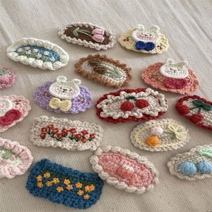 Macro detail of handmade crochet hair clips with cute flower and animal patterns