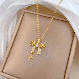 Detail shot of a butterfly pendant with colorful zircon stones and a gold star drop charm