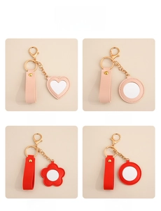 Detailed view of heart and flower shaped PU leather mirror keychains in pink and red