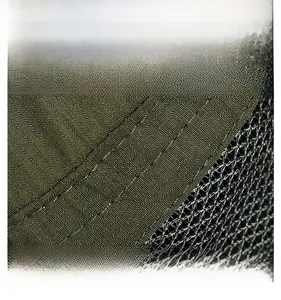 Macro detail of military green hat featuring durable mesh fabric and triple stitching