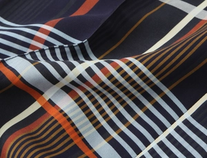 Detailaufnahme von hochwertigem dunkelblauem Karostoff mit orangefarbenen Streifen