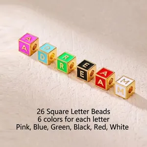 Macro view of square gold-plated letter beads with multi-color enamel inlay details