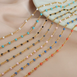 Elegant gold-plated titanium steel jewelry sets with colorful enamel beads displayed on marble