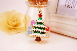 Detail of a Christmas tree keychain with colorful rhinestones and green enamel on gold metal