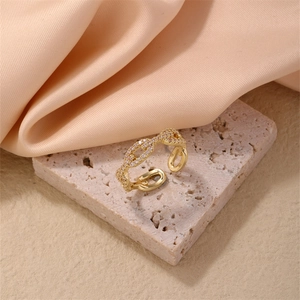 Detailed close-up of golden anchor link ring with sparkling cubic zirconia on stone base