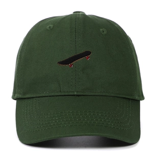 Close-up of a dark green cotton baseball cap featuring detailed skateboard embroidery