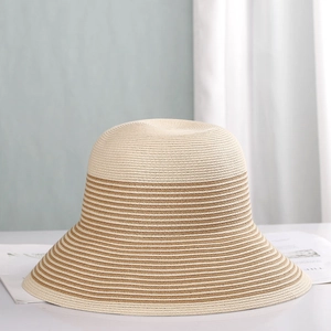 Detailed close-up of the fine straw weaving and brown striped pattern on the wide brim sun hat