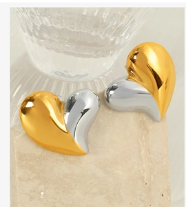 Gros plan de boucles d'oreilles cœur bicolores avec finition polie or et argent