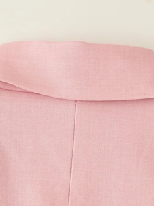 Dettaglio del colletto di un blazer rosa chiaro con trama in twill e cuciture rifinite
