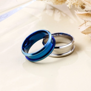 Close-up of blue and silver 8mm beveled edge stainless steel rings on a clean background