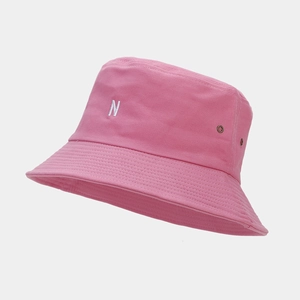 Détail d'un chapeau bob en coton rose avec broderie lettre N blanche et œillets en métal