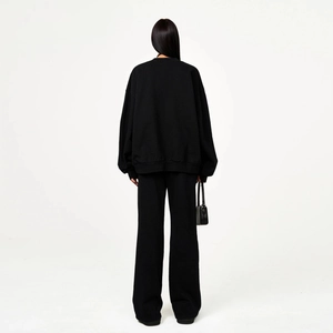 Back view of a black oversized tracksuit set featuring wide-leg pants and matching hoodie