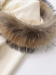 Close-up of beige fleece hoodie featuring premium detachable fur trim on the hood detail