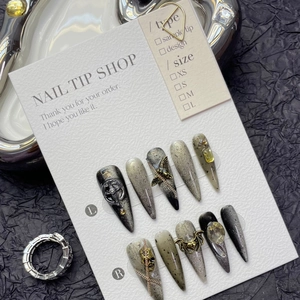 Handmade gothic black press-on nails with 3D chain and butterfly charms on display