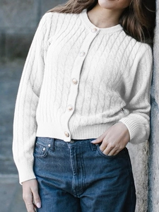 Detail of white knit cardigan with cable patterns and gold buttons on outdoor model