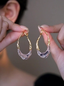Gros plan détaillé de boucles d'oreilles dorées 18k avec gouttes en résine texturée