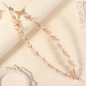Detailed view of handmade bridal hair vine with white enamel flowers and crystals