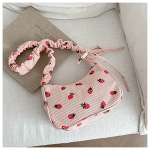 Detailed shot of pink strawberry print corduroy handbag with gathered shoulder strap
