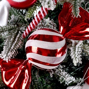 Christmas red and white candy cane ornaments with glitter finish on pine branch decor