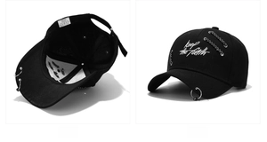 Detail view of cotton baseball cap with iron rings, chains and Keep The Faith embroidery