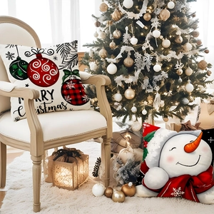 Housses de coussin de Noël avec bonhomme de neige et boules dans un décor festif