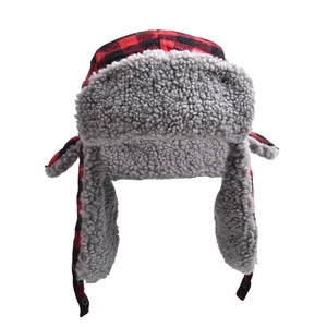 Detail of red buffalo plaid trapper hat with thick faux shearling lining and earflaps