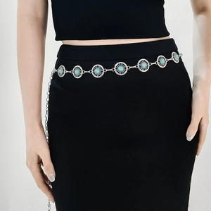 Silver metal chain belt with turquoise stones shown on waist over a black dress