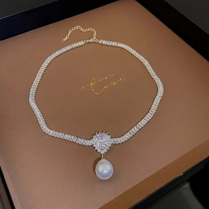 Gold plated pearl teardrop zircon necklace with heart-shaped stone on a jewelry display