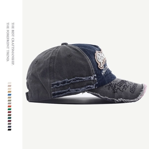 Detail view of vintage distressed denim baseball cap with embroidery and frayed edges