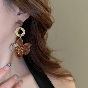 Macro shot of retro brown marble resin flower drop earring worn by model
